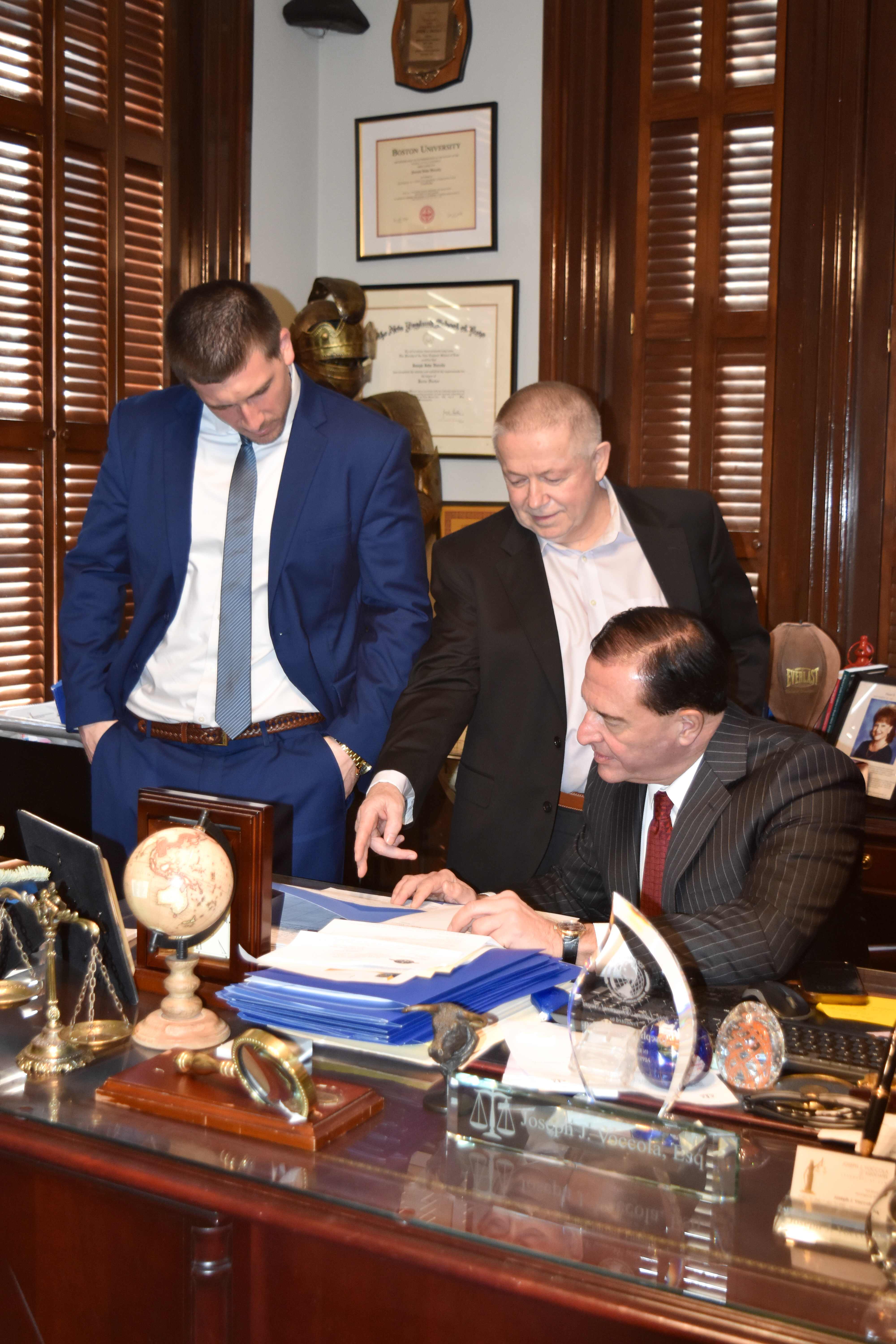 Joe Voccola consulting with team members in his office